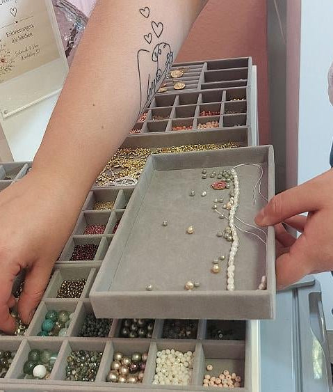 Hände wählen Perlen aus der Perlenbar aus bei dem Afterwork Schmuck  Workshop
