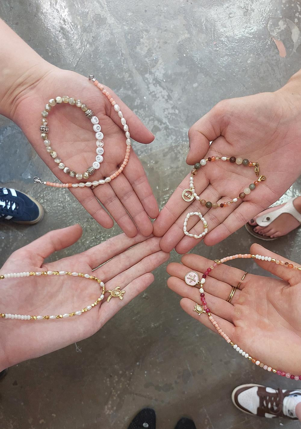 Hände zeigen ihre gebastelten Armbänder